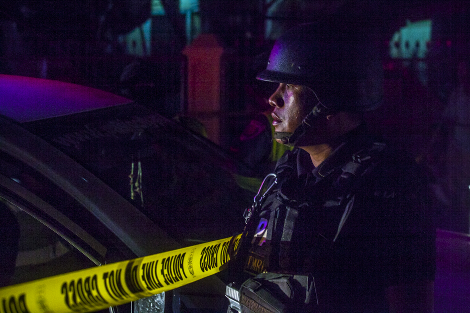 A heavily armored policeman watches over the police lines